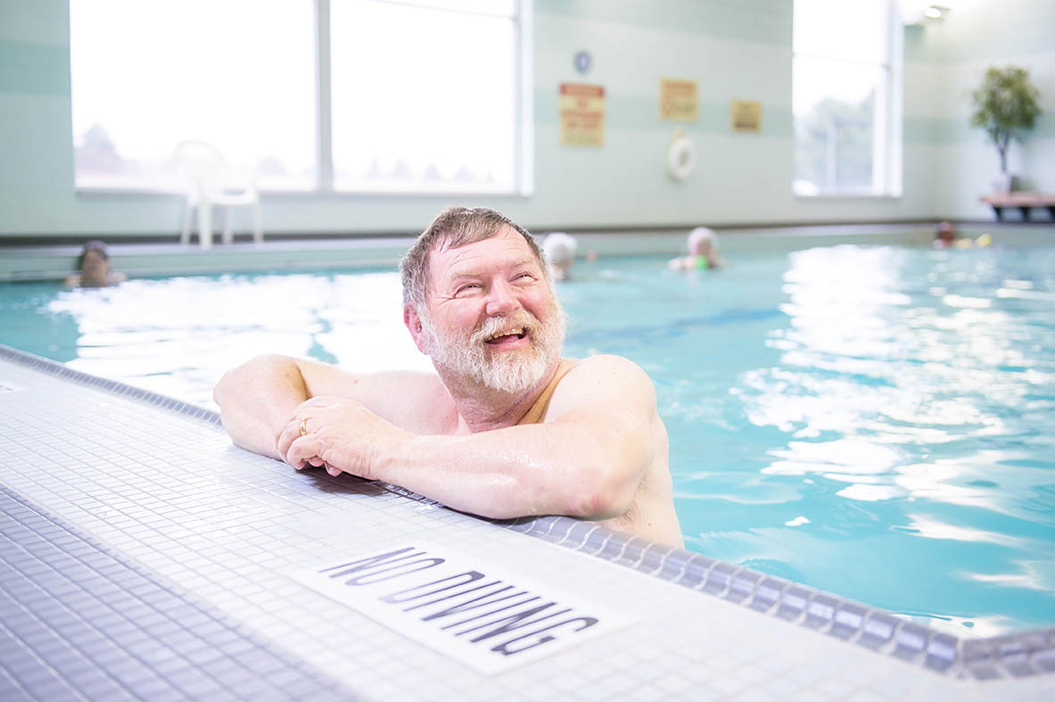 man swimming in pool smiling